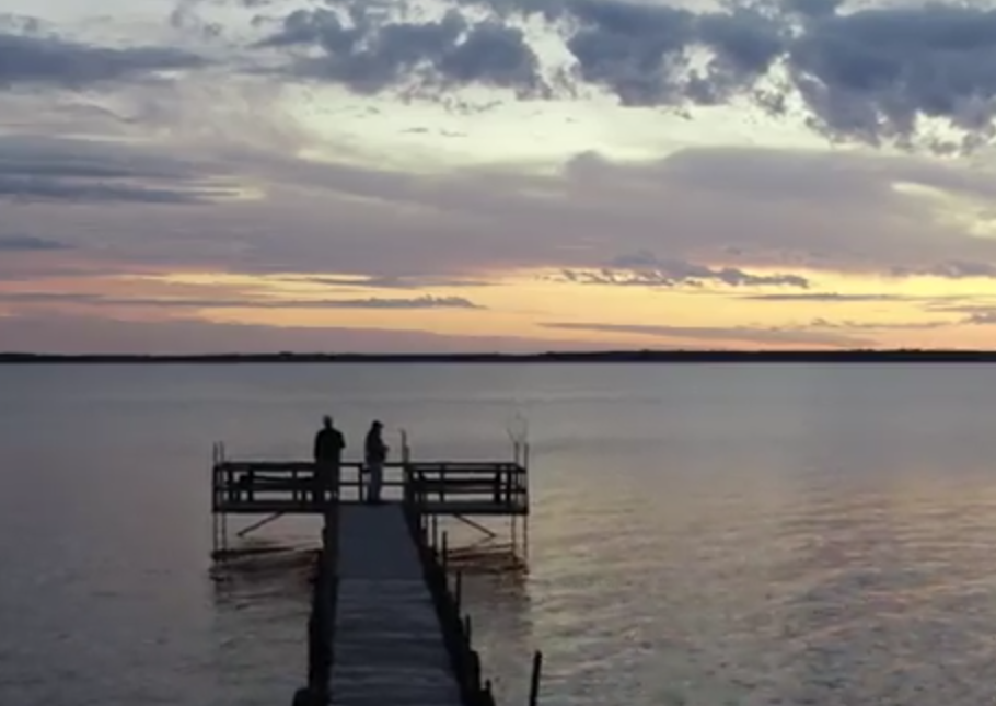 2 fishermen on dock at sunset